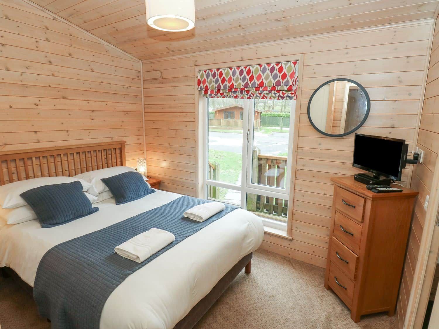 Spacious living area with dining table for six at Dovestone Secluded Lodge