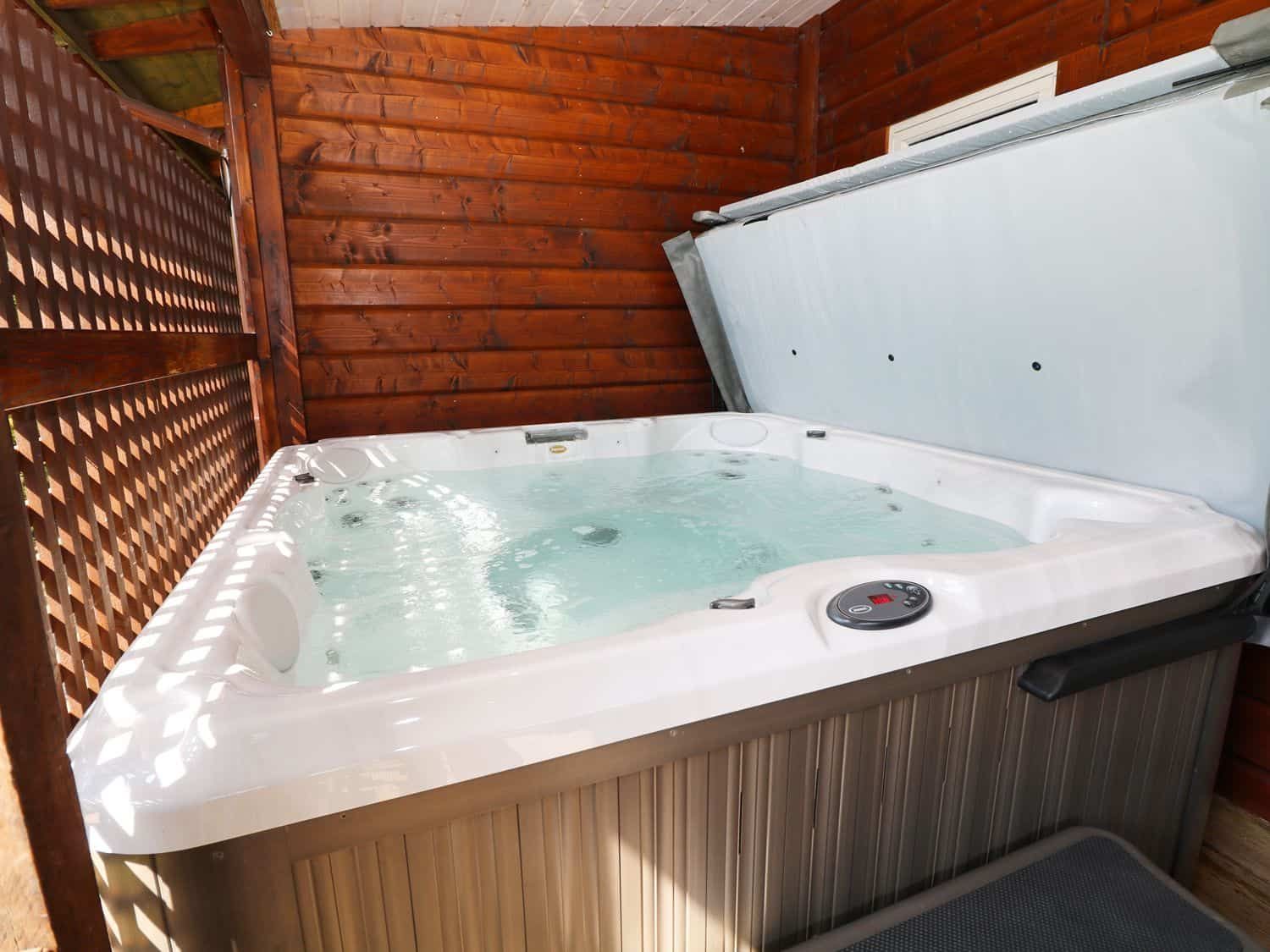 Sheltered hot tub on deck with lake views at Kipling Lodge Rudyard