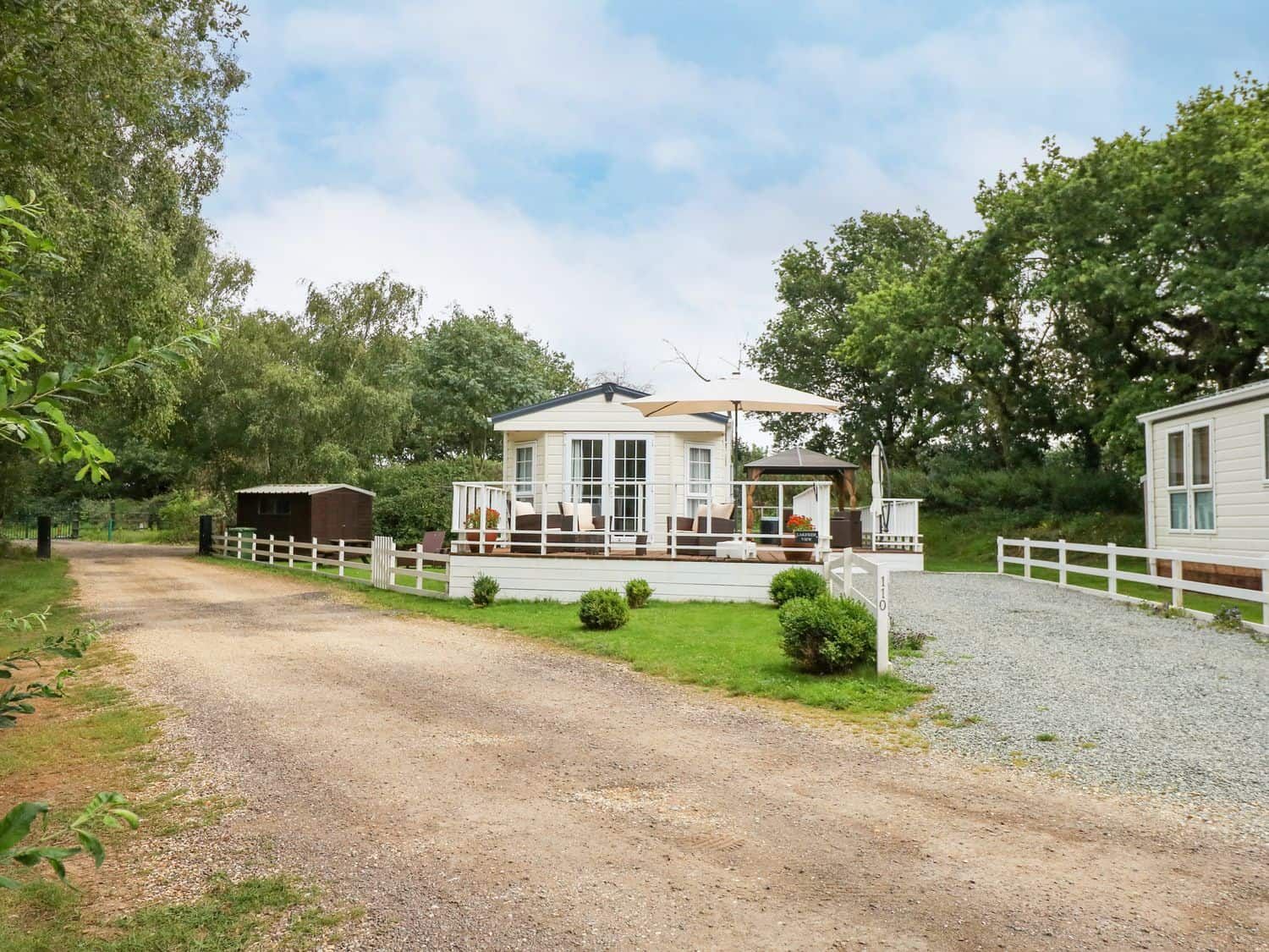 Lakeside View lodge with wraparound veranda overlooking the fishing lake at Pentney