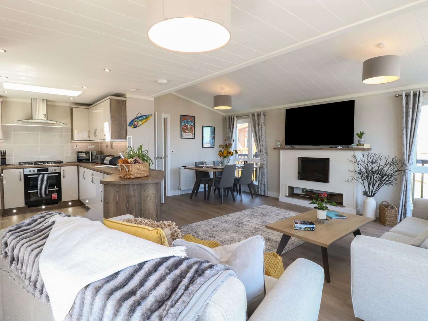 Stylish open plan living space with kitchen, fireplace and sea views