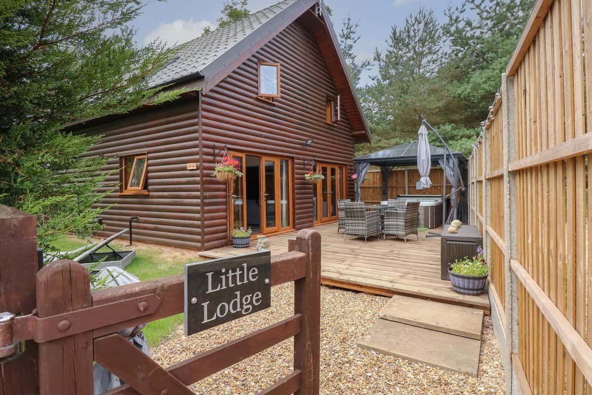 Little Lodge wooden cabin with deck and outdoor furniture at lakeside resort