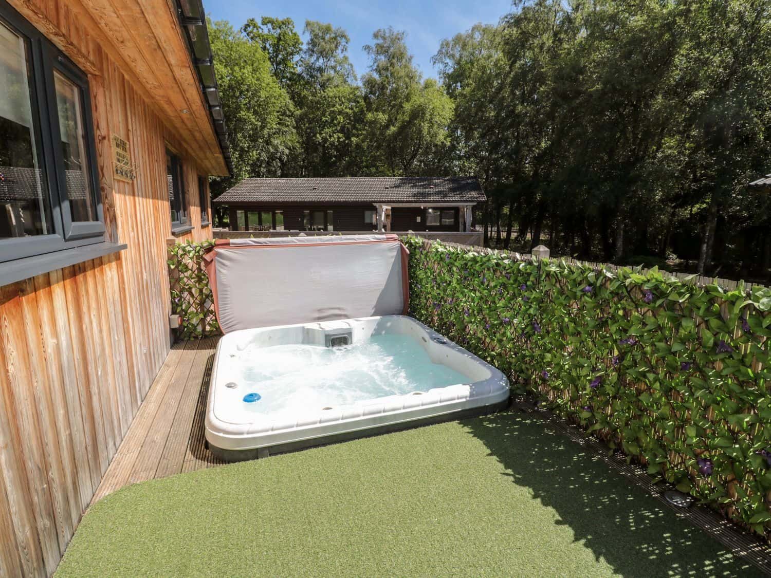 Hot tub on private decking with estate views at Lodge 32