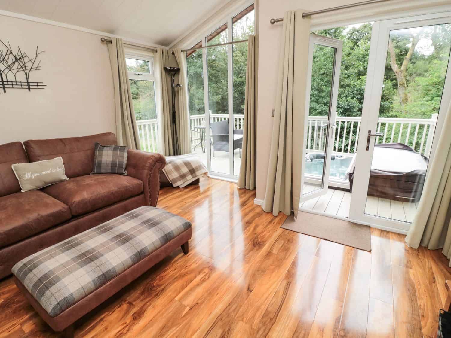 Comfortable living area with sofas and TV at Number 43 Burnside Lodge