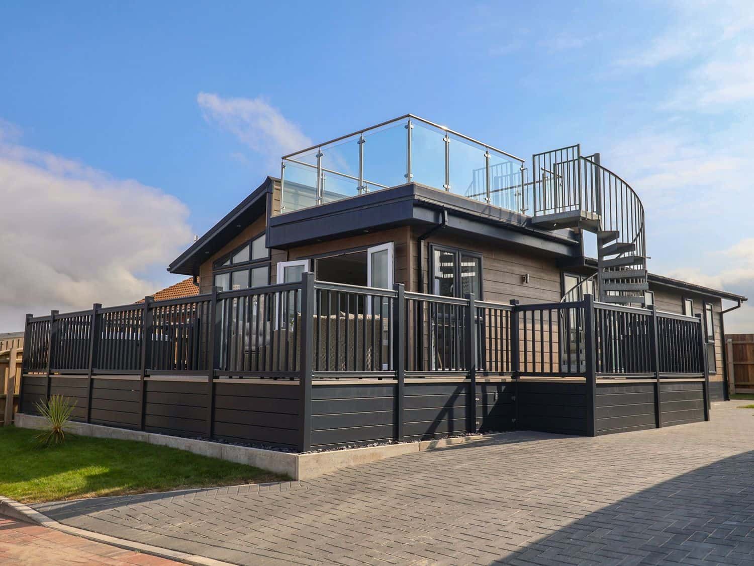 Sandy Snug modern coastal lodge with rooftop terrace overlooking the sea