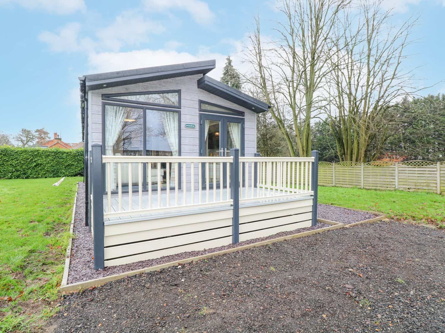 Modern Wurzburc cabin with glass doors and wooden deck in Norfolk countryside
